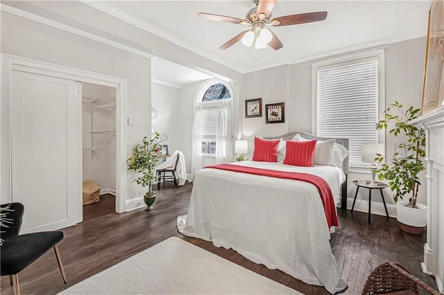bedroom with ceiling fan, baseboards, wood finished floors, and crown molding