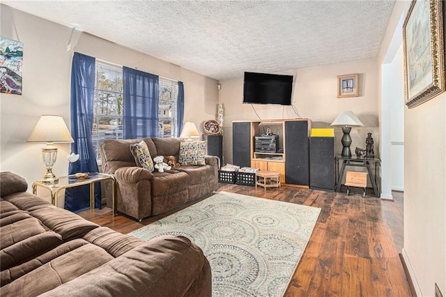 living room featuring dark wood-type flooring and a textured ceiling