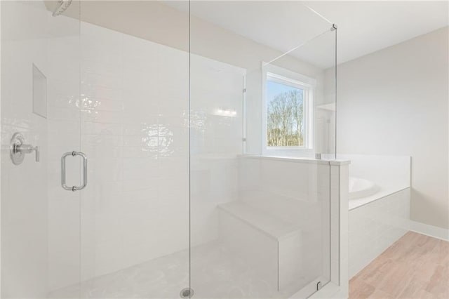 bathroom with plus walk in shower and wood-type flooring