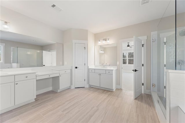 bathroom with ceiling fan, vanity, a shower with door, and a wealth of natural light