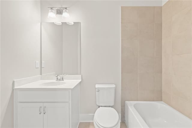 bathroom with vanity, a tub to relax in, and toilet