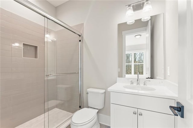 bathroom with vanity, an enclosed shower, and toilet