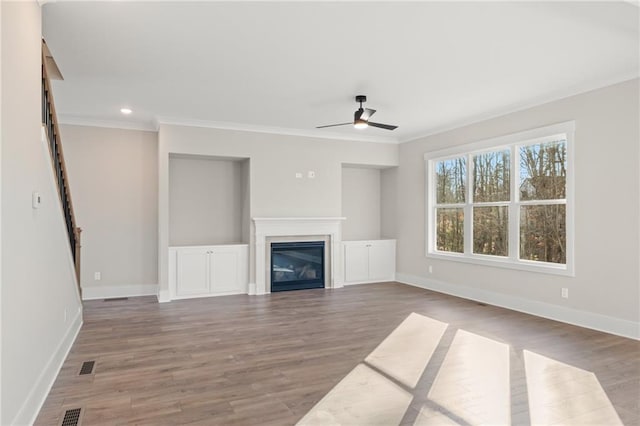 unfurnished living room with wood-type flooring, ceiling fan, and crown molding