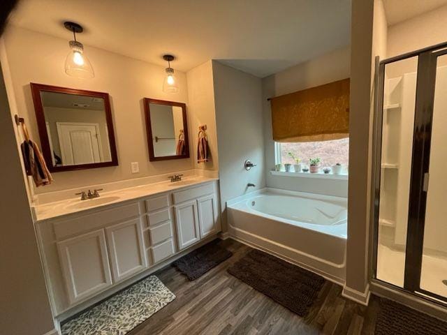 bathroom featuring vanity, wood-type flooring, and shower with separate bathtub