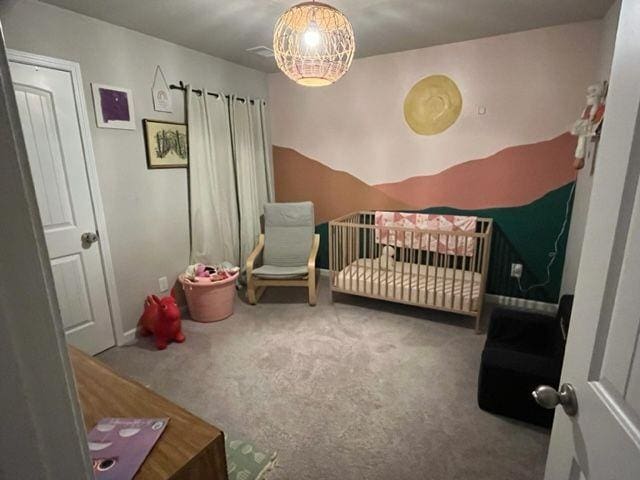 carpeted bedroom with a nursery area