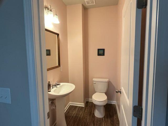 bathroom with wood-type flooring and toilet