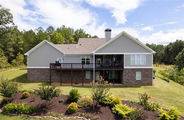 rear view of house featuring a yard and a deck