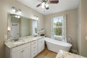 bathroom featuring hardwood / wood-style floors, a bathtub, ceiling fan, and vanity