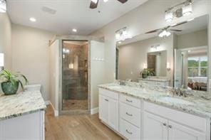 bathroom with hardwood / wood-style floors, vanity, and an enclosed shower