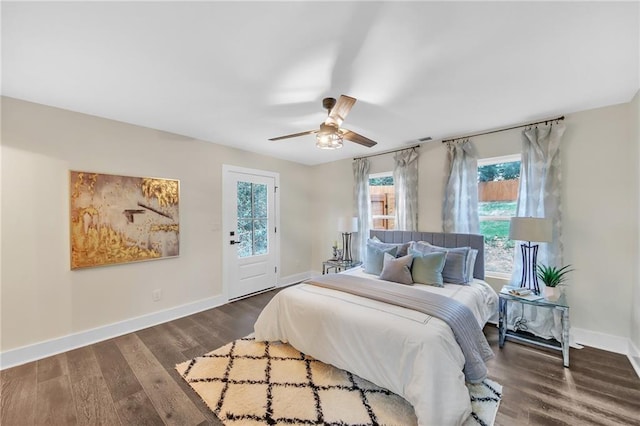 bedroom with multiple windows, ceiling fan, and dark hardwood / wood-style flooring