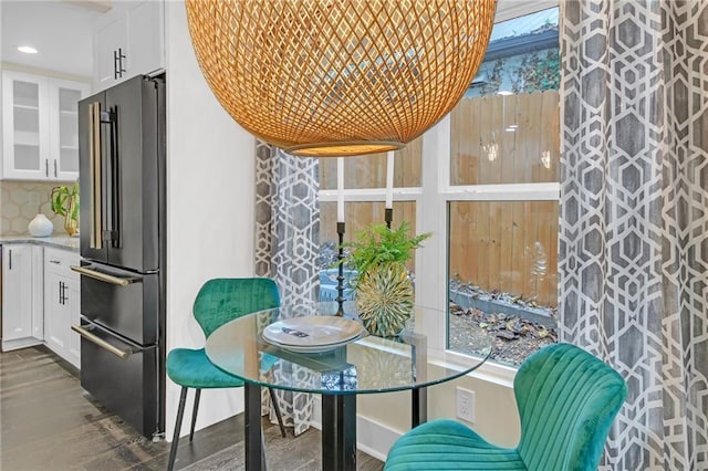 interior space featuring decorative backsplash, light stone counters, white cabinetry, and high end refrigerator