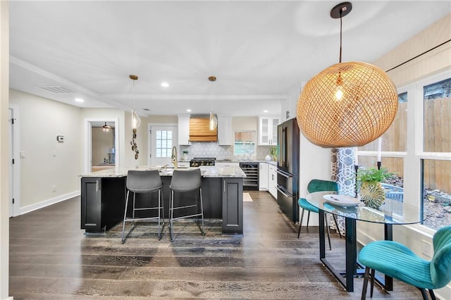 kitchen featuring tasteful backsplash, a kitchen island, dark hardwood / wood-style floors, white cabinetry, and hanging light fixtures