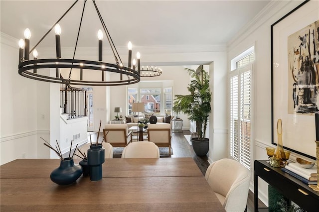 dining area featuring a healthy amount of sunlight, baseboards, crown molding, and wood finished floors