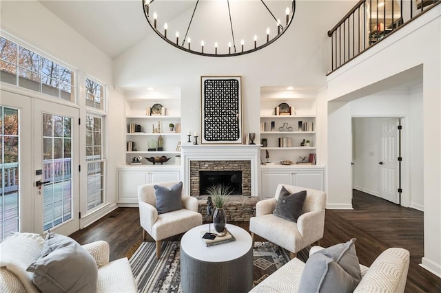 living room featuring dark wood-style floors, high vaulted ceiling, built in shelves, and a fireplace