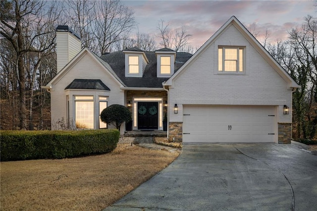 view of front facade featuring driveway, an attached garage, a lawn, and brick siding