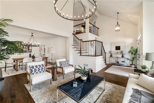 living room with high vaulted ceiling, wood finished floors, stairway, and an inviting chandelier