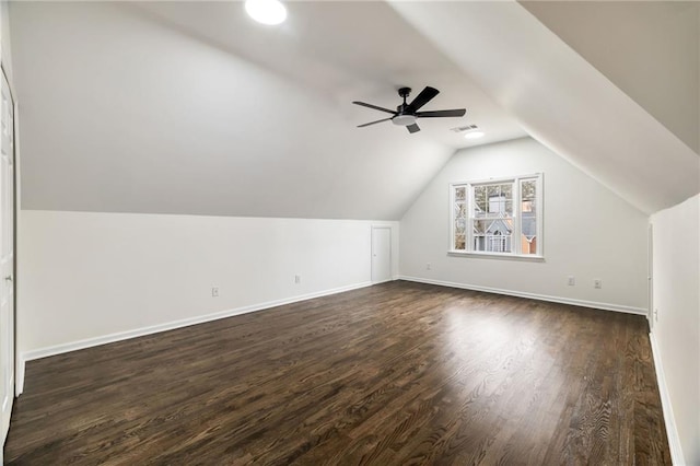 bonus room with lofted ceiling, baseboards, visible vents, and dark wood finished floors