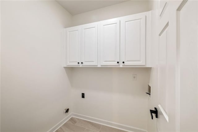 washroom featuring hookup for a washing machine, cabinet space, electric dryer hookup, and baseboards