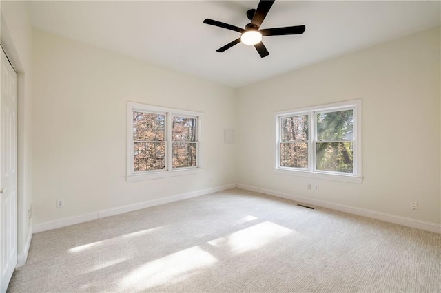 unfurnished bedroom with light carpet, visible vents, and baseboards