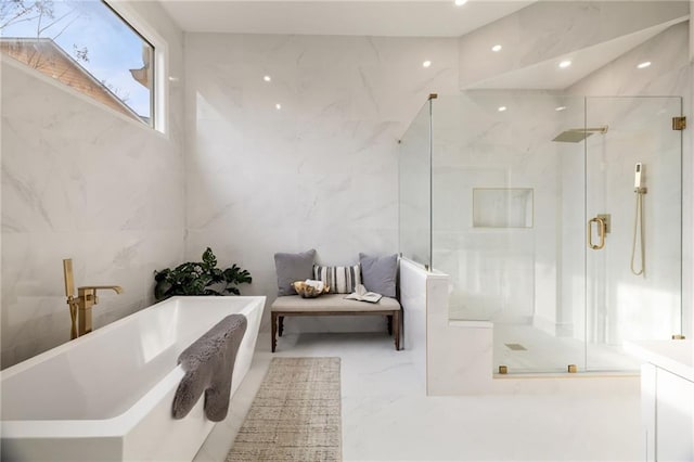 full bath featuring marble finish floor, tile walls, a marble finish shower, recessed lighting, and a soaking tub