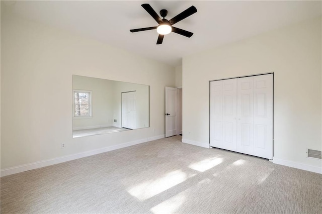 unfurnished bedroom featuring light carpet, a ceiling fan, visible vents, baseboards, and a closet