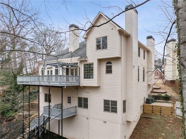 back of property with central air condition unit and a chimney