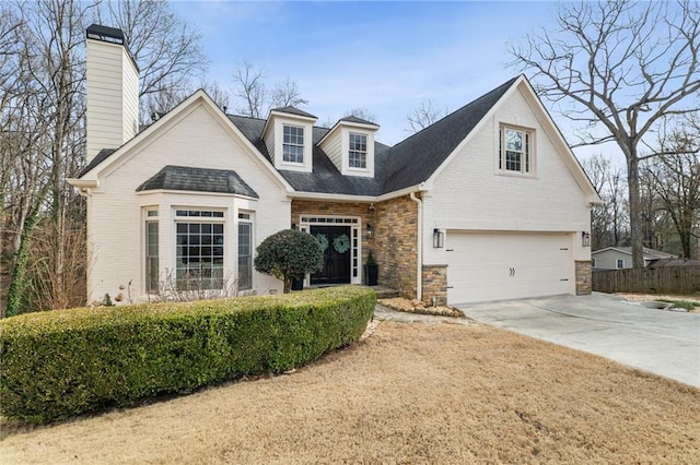 view of front of home featuring driveway, stone siding, an attached garage, and fence