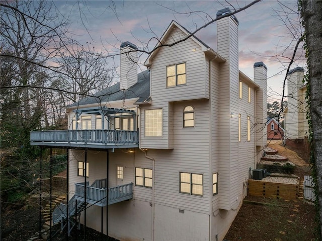 back of property with central AC and a chimney