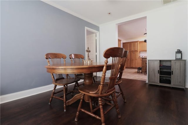 dining area featuring baseboards, ornamental molding, wood finished floors, and visible vents