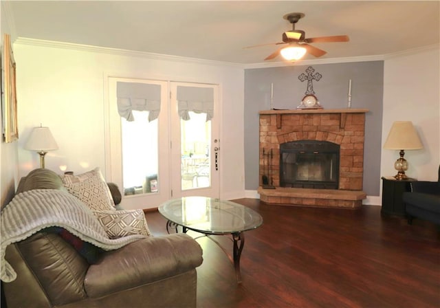 living room with a ceiling fan, wood finished floors, baseboards, a glass covered fireplace, and ornamental molding