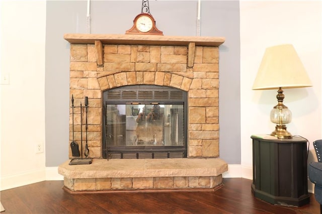 details with a glass covered fireplace, baseboards, and wood finished floors