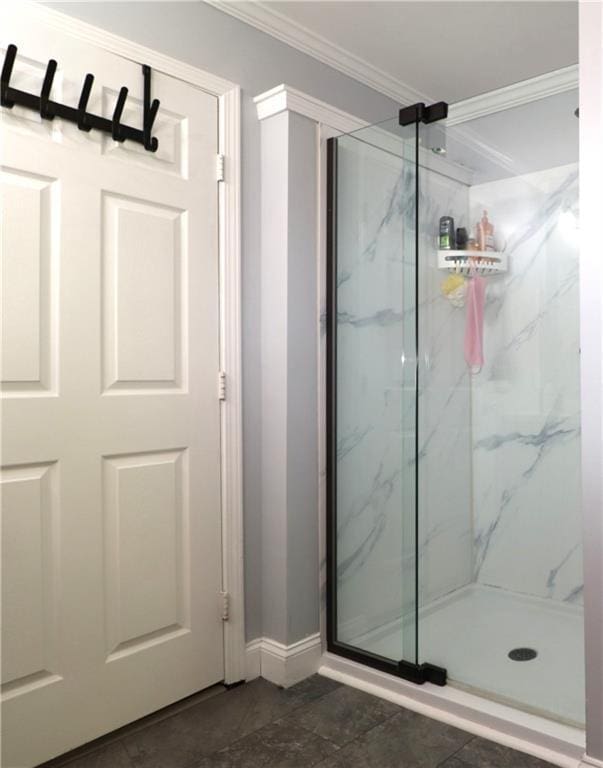 bathroom featuring crown molding, baseboards, and a marble finish shower