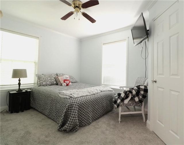 bedroom featuring ornamental molding, light carpet, and a ceiling fan