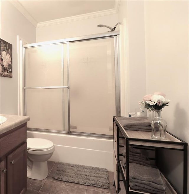 bathroom with vanity, toilet, tile patterned floors, combined bath / shower with glass door, and ornamental molding