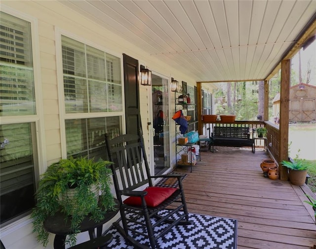 deck featuring a storage shed and covered porch