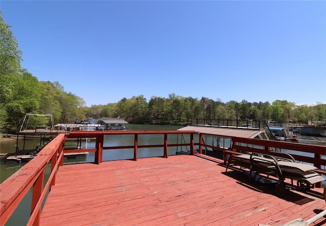 dock area with a water view and a wooded view