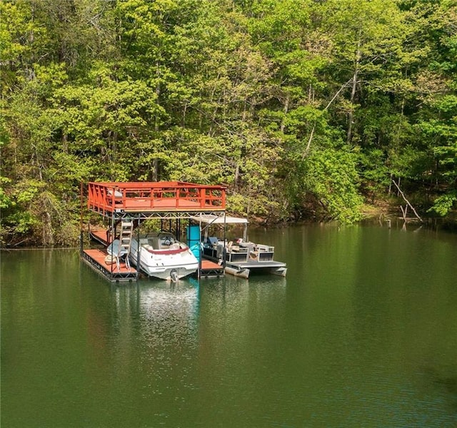 dock area featuring a forest view, a water view, and boat lift