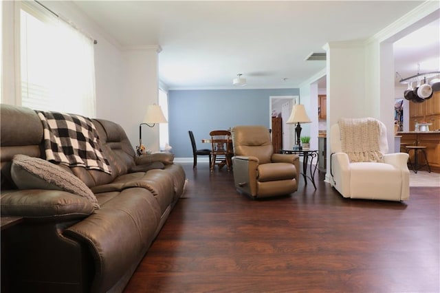 living room with baseboards, ornamental molding, wood finished floors, and visible vents