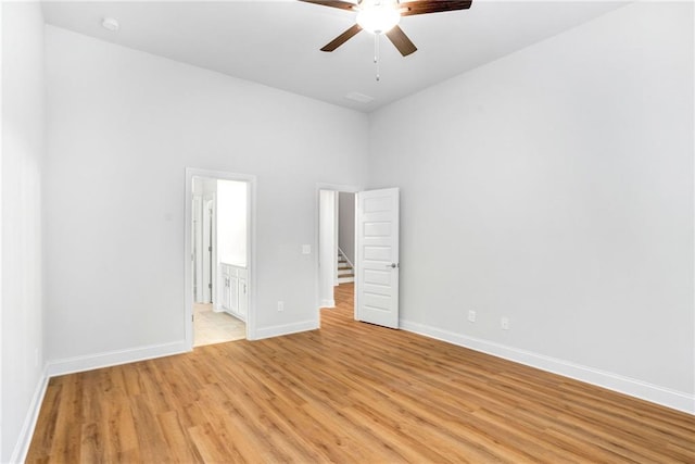 unfurnished bedroom featuring connected bathroom, light hardwood / wood-style flooring, and ceiling fan