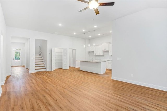 unfurnished living room with ceiling fan, sink, and light hardwood / wood-style floors