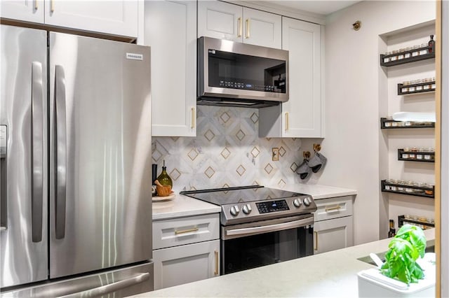 kitchen with white cabinets, appliances with stainless steel finishes, and tasteful backsplash