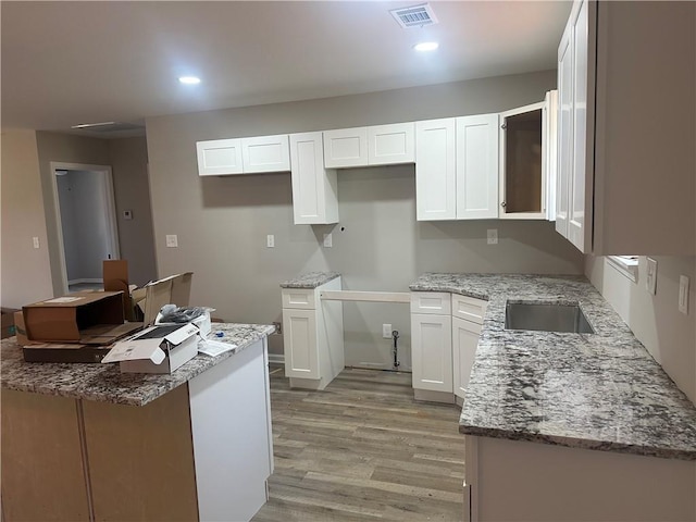 kitchen featuring light stone countertops, visible vents, recessed lighting, white cabinets, and light wood-type flooring