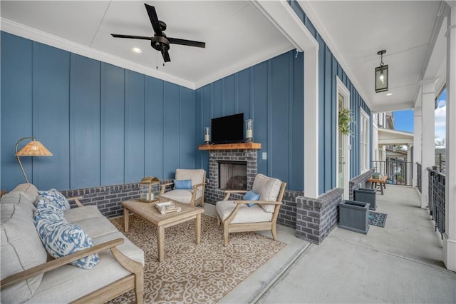 living area with ceiling fan, a brick fireplace, and ornamental molding