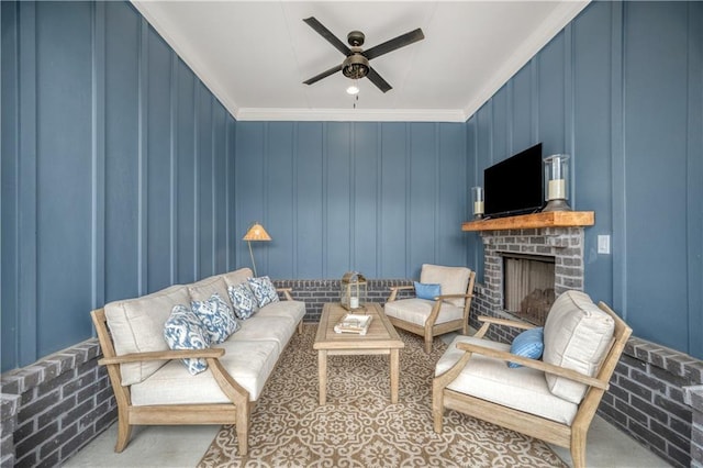 living area featuring a fireplace, a ceiling fan, and ornamental molding