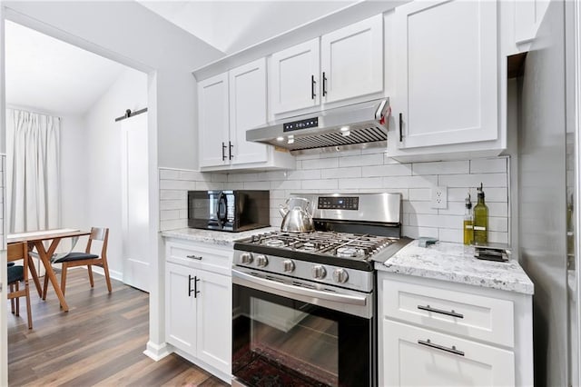 1208 Brandl Dr SW, Marietta, GA 30008 - kitchen featuring stainless steel appliances, under cabinet range hood, backsplash, vaulted ceiling, and wood finished floors