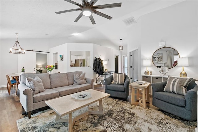 1208 Brandl Dr SW, Marietta, GA 30008 - living room with vaulted ceiling, ceiling fan, wood finished floors, a chandelier, and baseboards