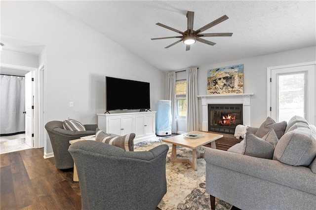 1208 Brandl Dr SW, Marietta, GA 30008 - living room with ceiling fan, dark wood-type flooring, a glass covered fireplace, vaulted ceiling, and a textured ceiling