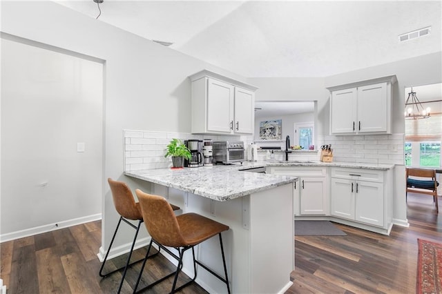 1208 Brandl Dr SW, Marietta, GA 30008 - kitchen with a sink, a peninsula, backsplash, and a breakfast bar area