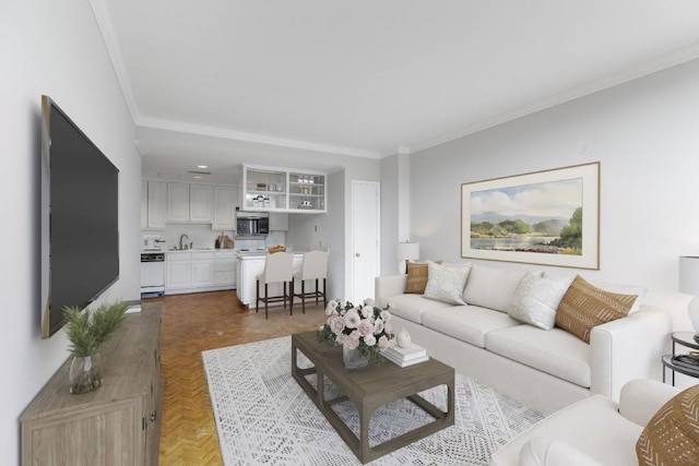 living room featuring crown molding, parquet flooring, and sink