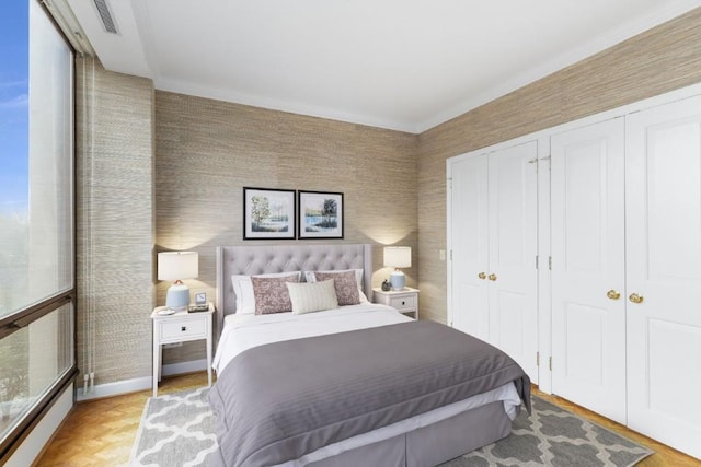 bedroom with light parquet flooring and two closets